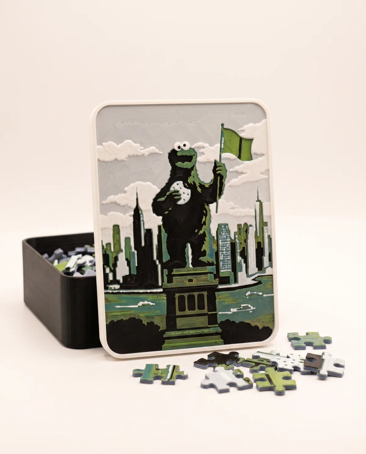 3D printed gift box: the lid with the puzzle photo in relief leaning on the open box, a few puzzle pieces in front